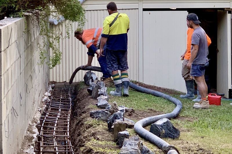 Pouring concrete into foundation for the rock wall in Corinda, Queensland